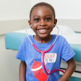 Young patient wearing a stethoscope and smiling