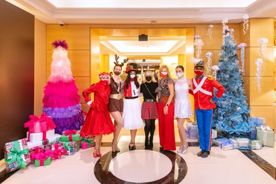 Founders Auxiliary Board Members dressed festively in front of holiday decor in the Four Seasons lobby